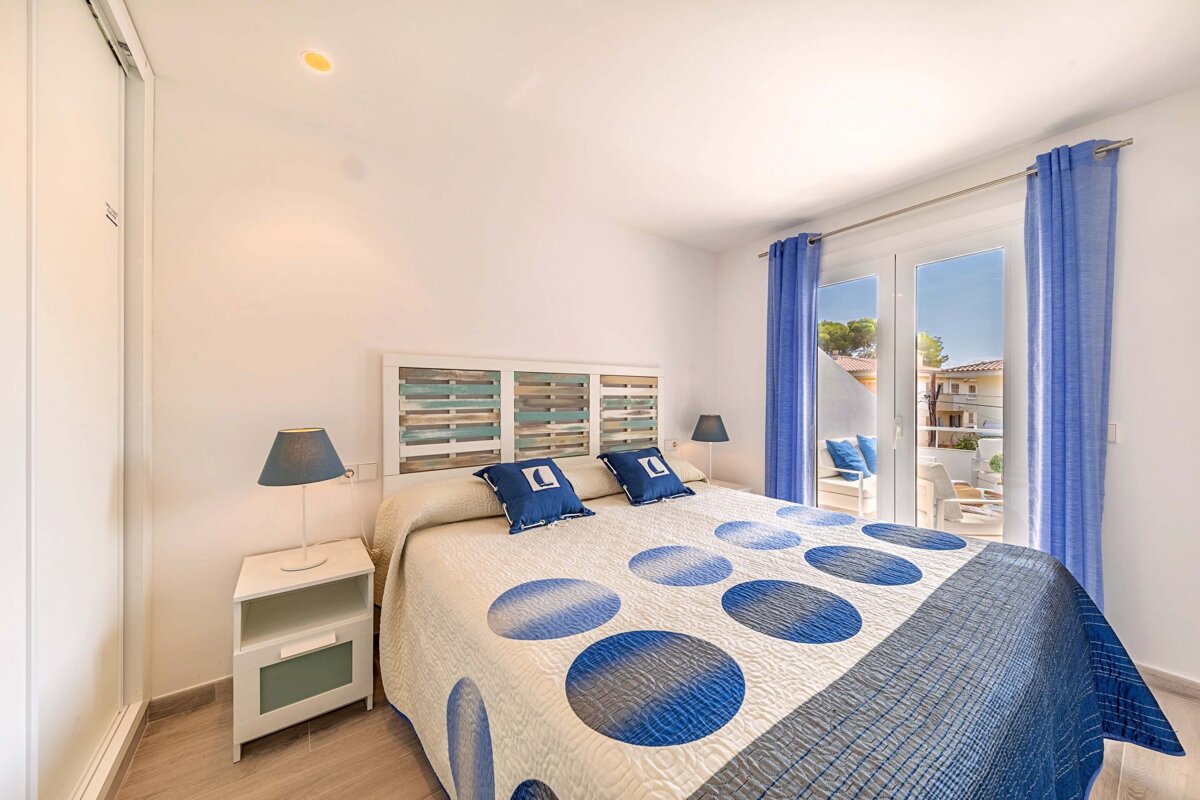 A bedroom with a blue and white polka dot blanket