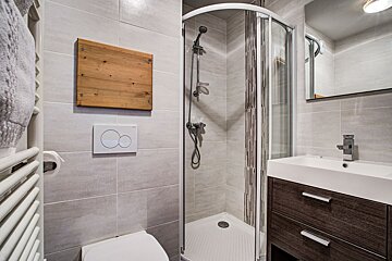 A bathroom with a walk in shower and a toilet