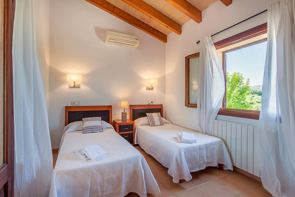 A bedroom with two twin beds and a window