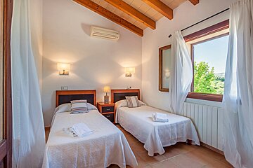 A bedroom with two twin beds and a window