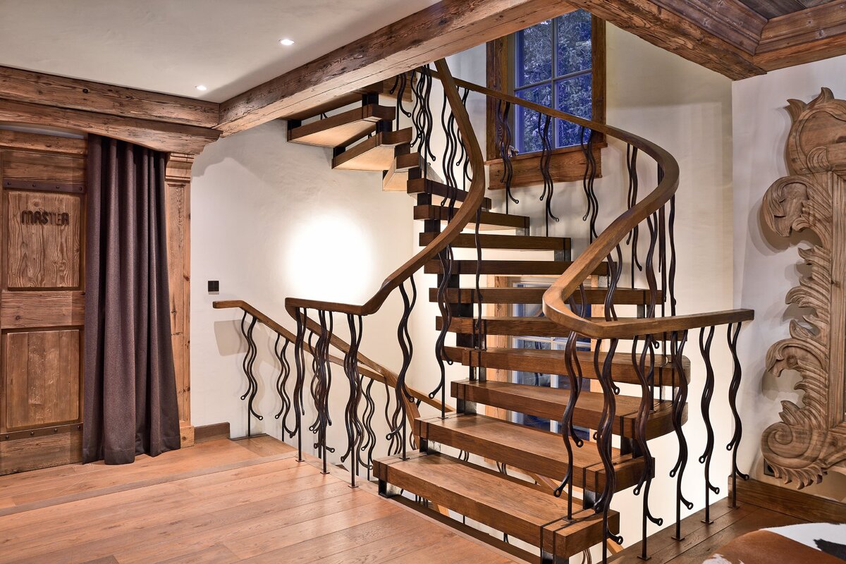 A wooden staircase with a metal railing and a sign that says master