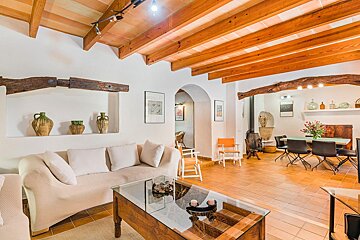 A living room with a white couch and a glass coffee table