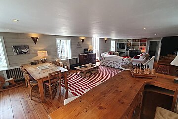 A living room with a table and chairs and a chess board