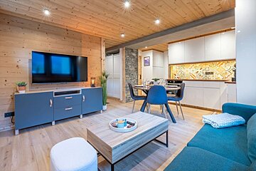 A living room with a blue couch and a flat screen tv