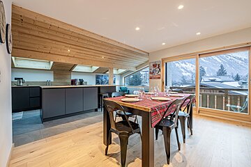 A kitchen with a table and chairs and a sign that says smirnoff
