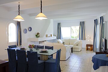 A living room with a dining table and chairs