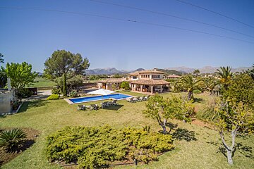 An aerial view of a large house with a swimming pool