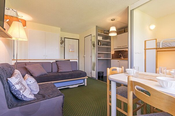 A living room with a couch and a table and chairs