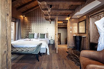 A bedroom with a king size bed and a chair