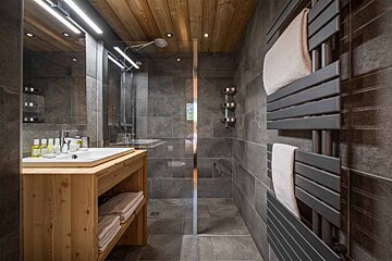 A bathroom with a walk in shower and a sink