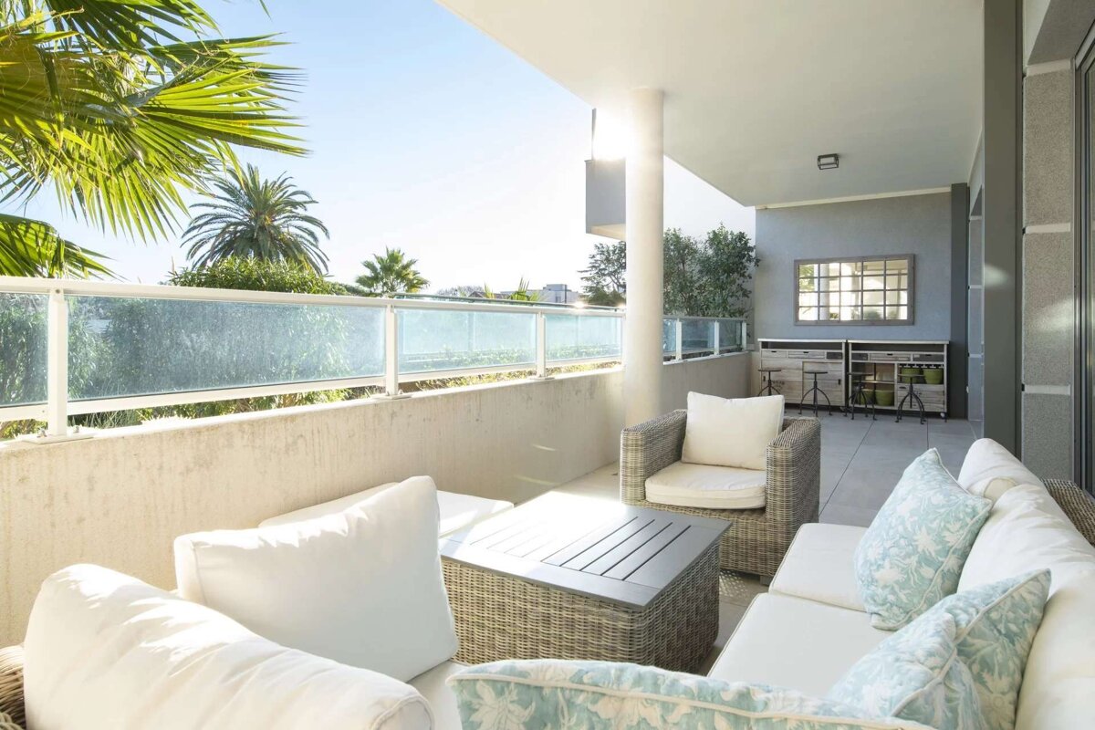 A balcony with a couch and chairs and a table