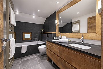 A bathroom with two sinks and a bathtub