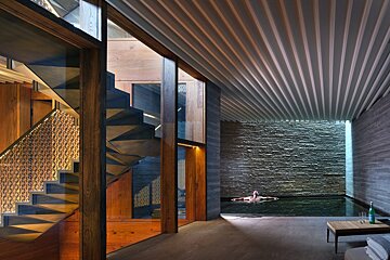 A woman is swimming in a pool in a house