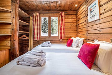 A bedroom with two beds and a poster on the wall that says combloux