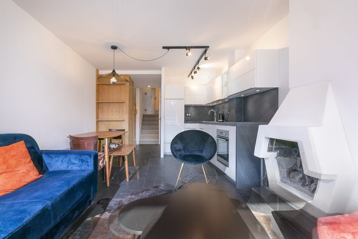 A living room with a blue couch and a black chair