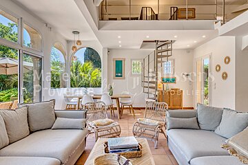 A living room with a spiral staircase leading to the second floor