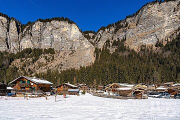 A snowy landscape with a mountain range in the background