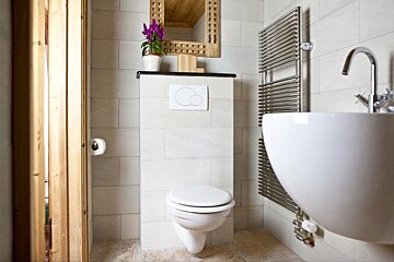 A bathroom with a toilet a sink and a mirror