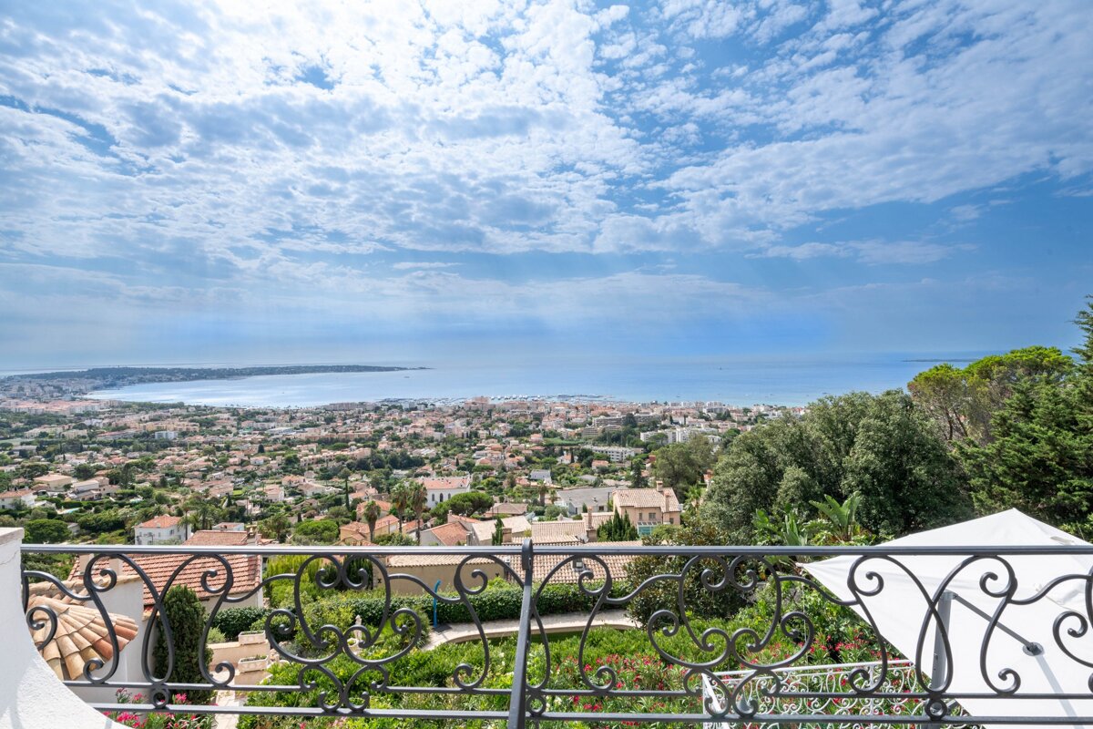 A balcony with a view of a city and the ocean