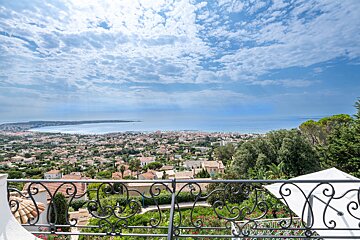 A balcony with a view of a city and the ocean