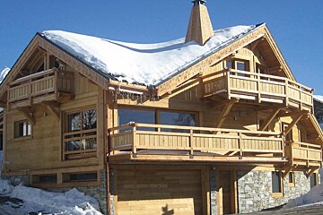 A large wooden house with snow on the roof