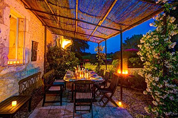 A covered patio with a table and chairs and candles