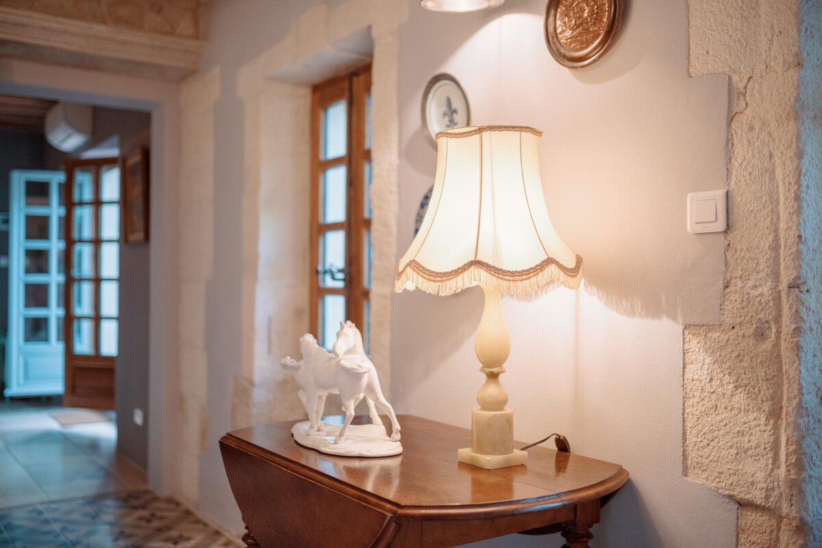 A lamp sits on a table next to a statue of a horse