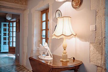 A lamp sits on a table next to a statue of a horse