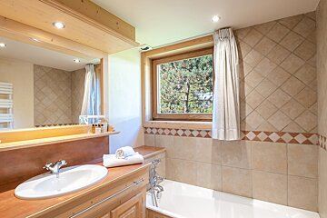 A bathroom with a sink and a bathtub and a window