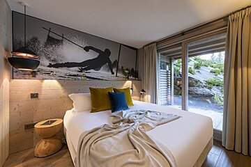 A bedroom with a painting of a skier on the wall