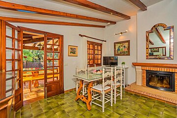A living room with a table and chairs and a fireplace
