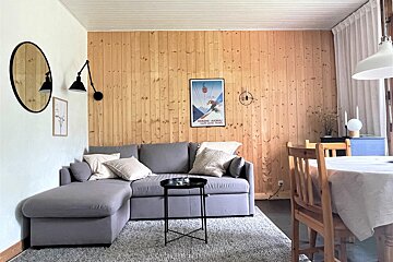 A living room with a couch and a poster on the wall that says altitude altitude