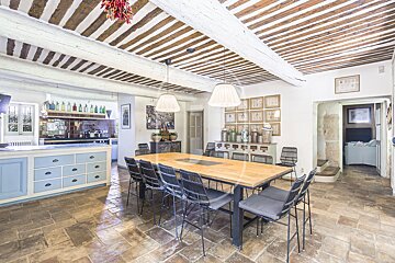 A dining room with a large wooden table and chairs