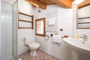 A bathroom with a toilet a sink and a window