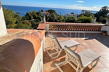 A balcony with chairs and a sign that says home sud