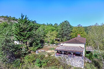 An aerial view of a house in the middle of a forest