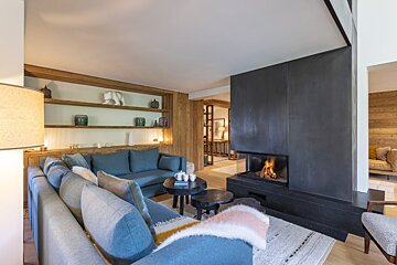 A living room with a blue couch and a fireplace