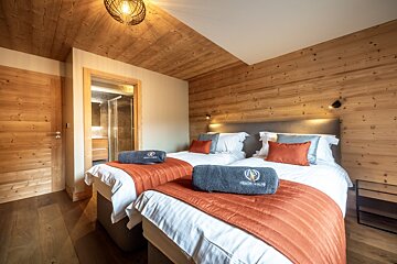 A hotel room with two beds and a towel that says montagne
