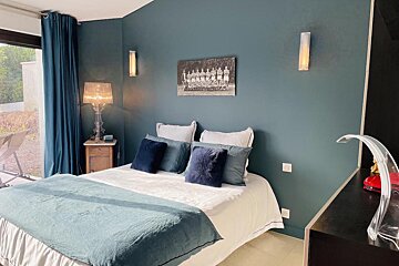 A bedroom with a bed and a picture on the wall