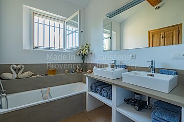 A bathroom with two sinks and a window that says made in janssens provence
