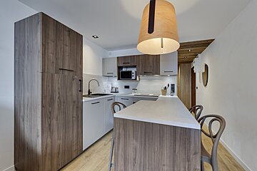 A kitchen with wooden cabinets and white counter tops