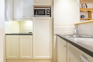 A kitchen with white cabinets and a brandt dishwasher