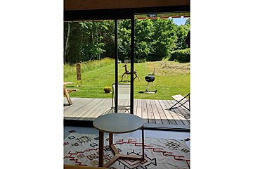 A sliding glass door opens to a lush green field