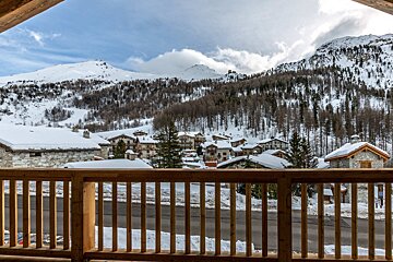 A view of a snowy mountain village from a balcony