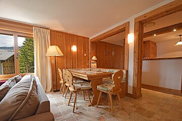 A living room with wood paneling and a table and chairs