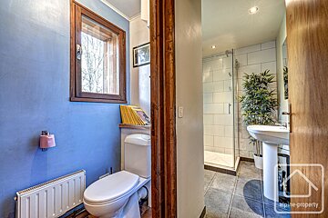 A bathroom with a toilet and a sink and a sign that says alpine property