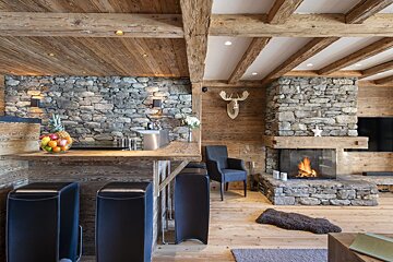 A living room with a stone wall and a fireplace