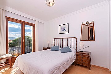 A bedroom with a large bed and a mirror
