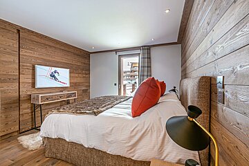 A bedroom with a large bed and a flat screen tv