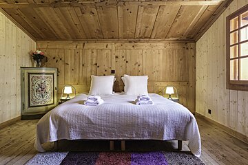 A bedroom with a bed and a dresser with flowers painted on it